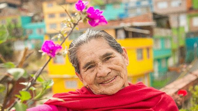 Ana Celia García con una de las plantas de buganvilia que le dio el Distrito