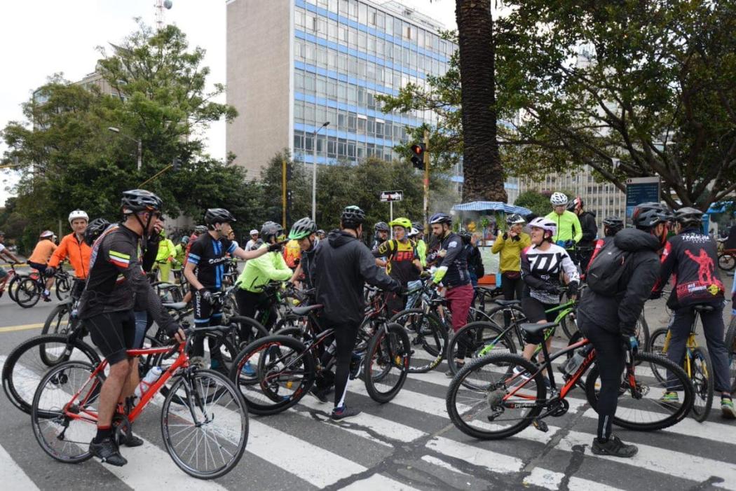 Un grupo de gente montada en bicicleta pasando una calle 