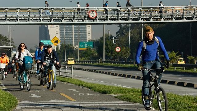 Una avenida y varias personas en cicla movilizandose por esta 