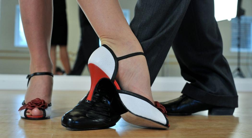 Pareja de bailarines de tango. Primer plano de sus pies.