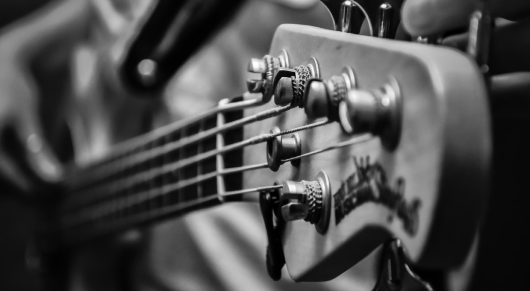 Primer plano de las cuerdas de una guitarra en blanco y negro.