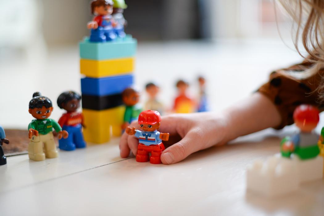 Una niña juega con unos muñecos pequeños en las vacaciones recreativas