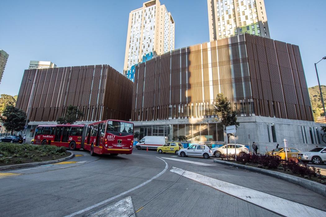 Fachada de la nueva Cinemateca de Bogotá, un transmilenio en la esquina izquierda inferior esta dando la vuelta y el sol pega en toda la fachada