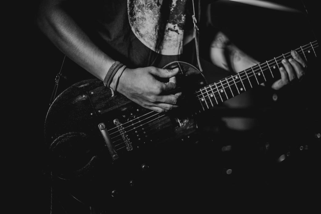 Un hombre tocando la guitarra eléctrica en un concierto de rock