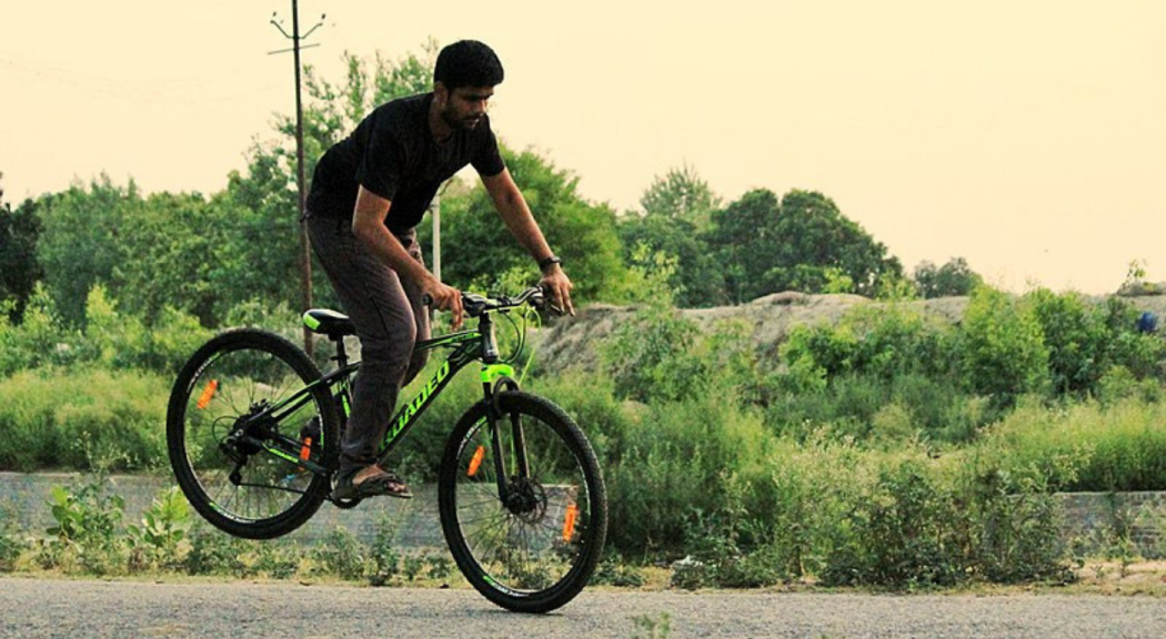 Un hombre joven monta bicicleta.