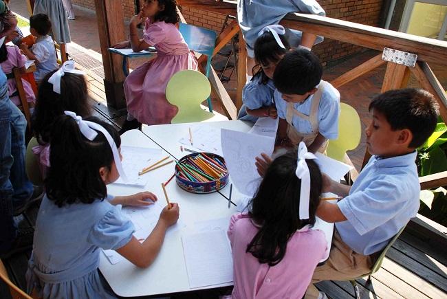 Plano general de niños de diferentes edades estudiando.