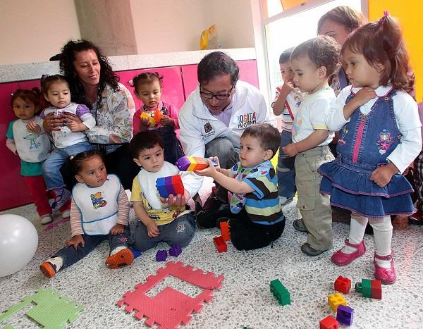 Mujeres y niños pequeños juegan en un jardín infantil.