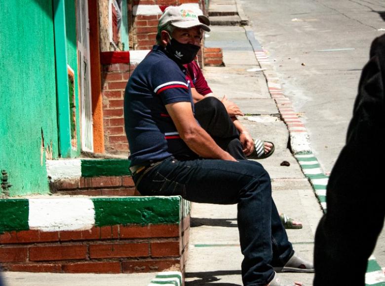 Personas sentadas en un andén.