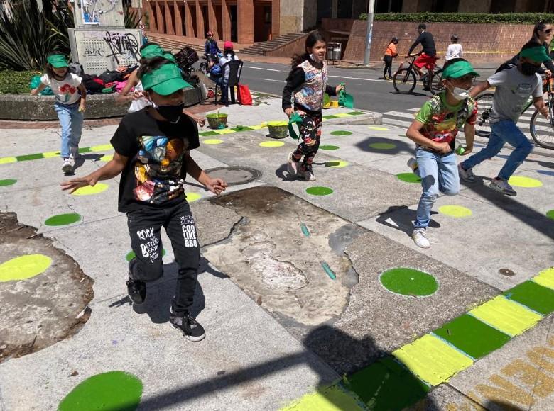 Niños jugando en un espacio pintado por funcionarios de Movilidad.