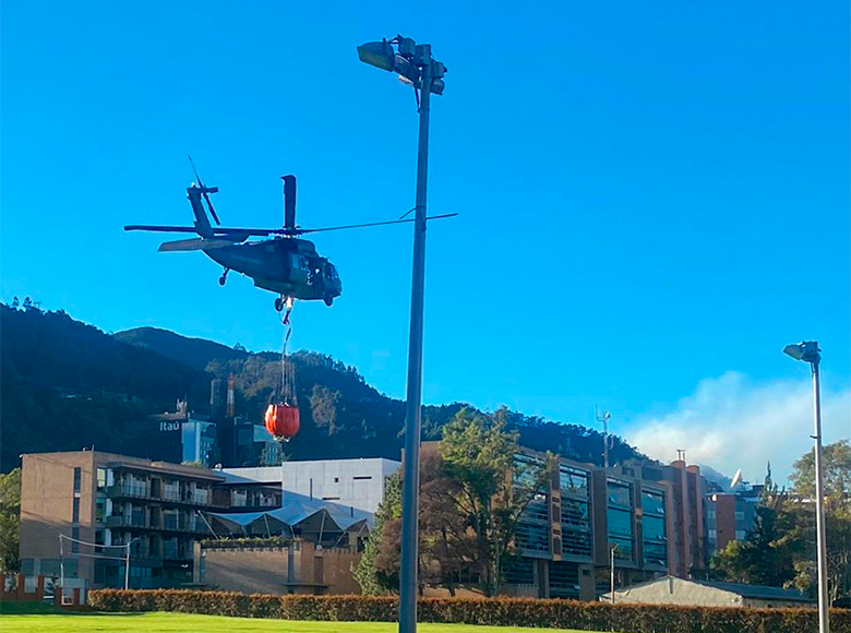 Se realizan acciones manuales en tierra y con apoyo de un helicóptero de la Fuerza Aérea, se descarga agua y líquido retardante para el control del incendio que se presenta en los Cerros Orientales.