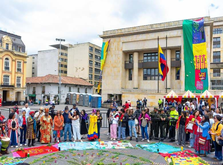 Evento simbólico de arropamiento con telas tejidas por las víctimas y sus relatos.