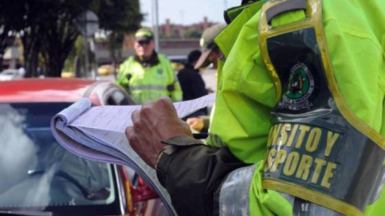 Agente de tránsito imponiendo un comparendo a un conductor infractor.