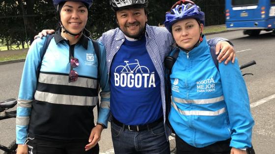 Hombre blanco, de pelo castaño y mediana estatura abrazando a dos mujeres. 